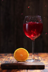 Splash red wine in glass on wooden table