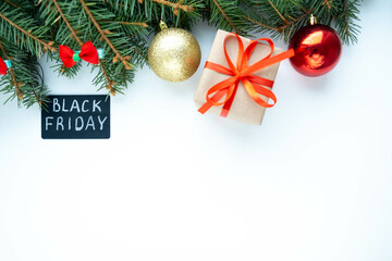 Black Friday big sale promotional sign on white background with fir branches, Christmas balls and gift. Special discount offer. Advertising message. Holiday shopping. Top view, copy space for text