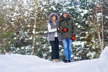 Fototapeta na wymiar Couple having fun with sledge on snow in winter