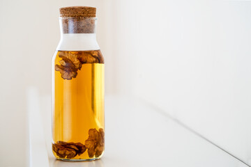 Soaked and brewed raw walnut kernels in glass bottle. Detox diet and antioxidant recipe concept.