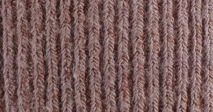 The texture of the knitted part is close-up. Macro fragment. Brown background.