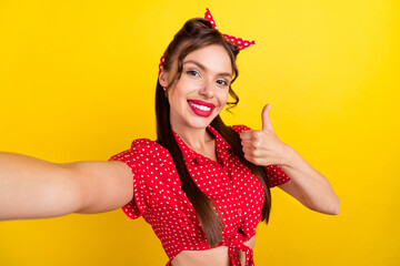 Photo of cute pretty young woman dressed red clothes smiling recording video showing thumb up isolated yellow color background