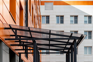 Glass canopy to protect from precipitation at the entrance to a modern office building.