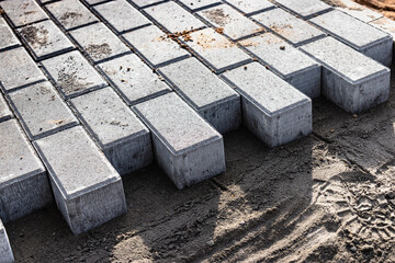 Pavement repair and laying of paving slabs on the walkway, stacked tile cubes on the background. Laying paving slabs in the pedestrian zone of the city, sand filling. Road tiles and curbs.