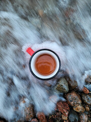 Top view of sea foam in motion and static mug with drink