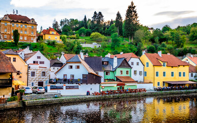 Fototapeta premium Beautiful view of river stony quay and old buildings on the background of green forest hill