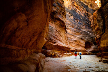 Group of people between sandstone rocks at narrow path in Petra, Jordan