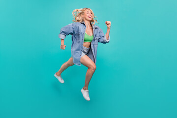 Fototapeta na wymiar Full size photo of happy cheerful positive woman jump up run empty space isolated on blue color background