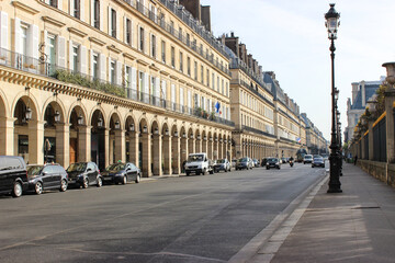 Cozy small streets of Paris. Everyday life. Beige buildings with several floors. Roads with cars,...