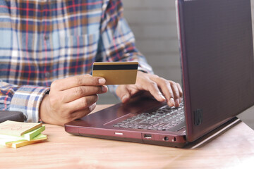 man hands holding credit card and using laptop shopping online 
