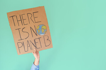 Stop climate change concept. Hand with denim jacket holding a there is no planet b cardboard sign...