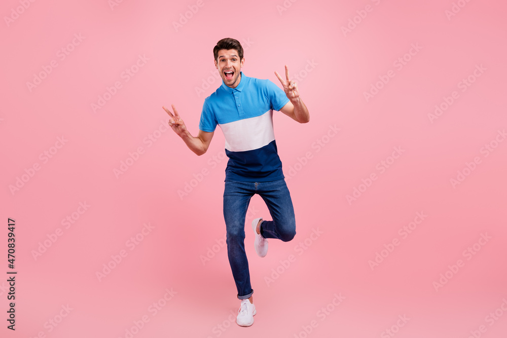 Sticker Full size photo of cool brunet young guy go show v-sign wear polo jeans sneakers isolated on pink background