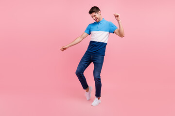Fototapeta na wymiar Full body photo of lovely brunet young guy dance wear polo jeans sneakers isolated on pink background