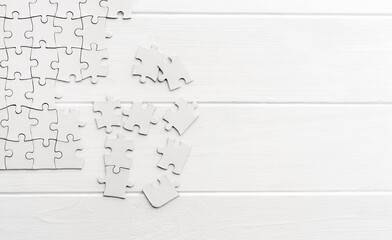 Pieces of empty jigsaw puzzle on white table
