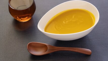 カボチャと人参で作った黄色が鮮やかなのポタージュスープ（黒背景）