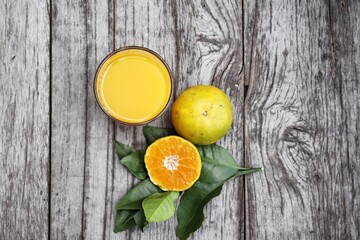 Orange juice and fruit on wood background