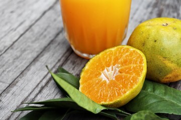 Orange juice and fruit on wood background