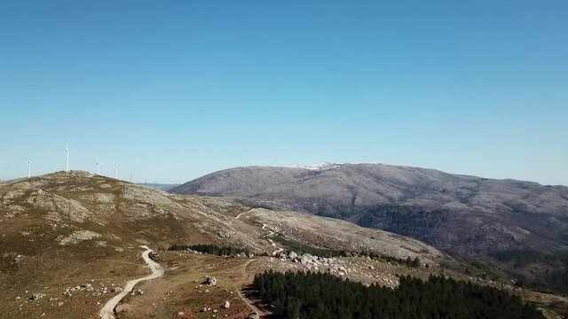 Cinematic Drone Footage Aerial Shot of a Pine Forest and mountains with dirt road. Scenic view of mountains in Portugal.