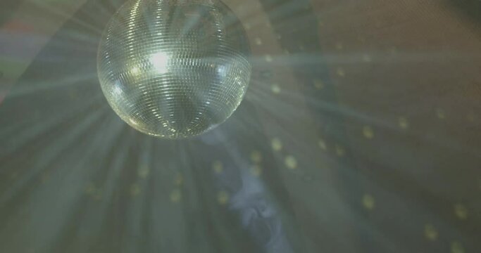 illuminated disco mirror ball hangs on ceiling, goes into heavy blur