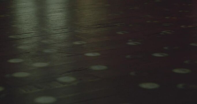 Reflections of a mirror ball on a wooden dance floor