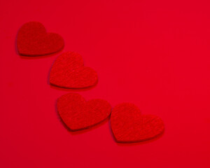 Red felt hearts love decor on the red background