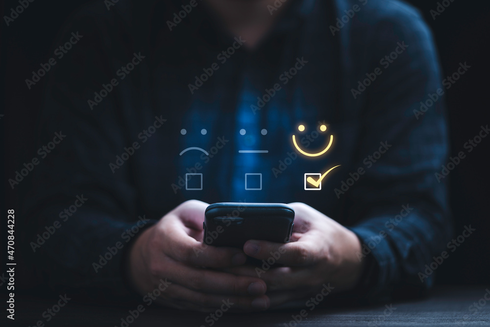 Poster Businessman using smartphone for select smiley face icon for client evaluation and customer satisfaction after use product and service concept.