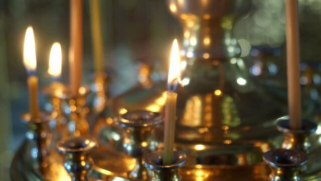 Orthodox tradition. Candles are burning in the church in front of images and icons in floor candlesticks. Prayer for health, deliverance from disease. Church service on Christmas night.