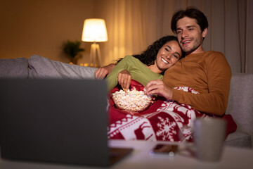 Couple Enjoying Christmas Eve Watching Xmas Movies Online At Home
