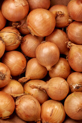 Lots of orange onions on top of each other close up 