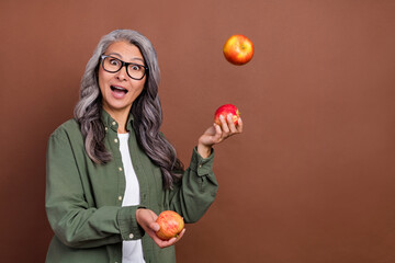 Photo of impressed old grey hairdo lady juggle wear shirt eyesight isolated on brown color background