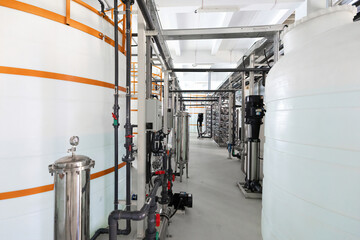 Close-up photo of white pipes and tanks. Chemistry and medicine production. Pharmaceutical factory. Interior of a high-tech factory