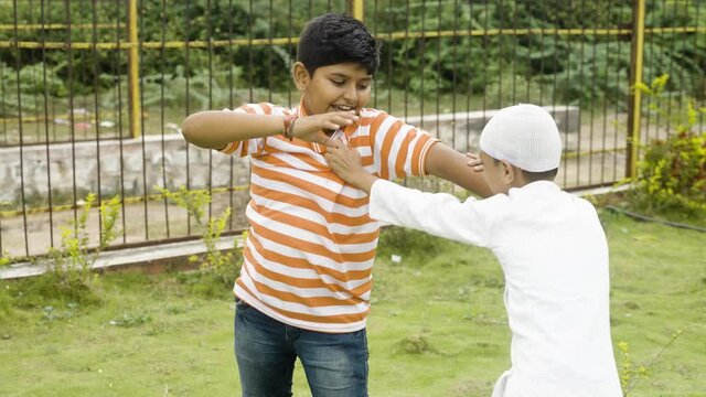 Indian multiethnic kids fighting while playing at park - concept showing of children quarrel, communal violence, conflict or clash