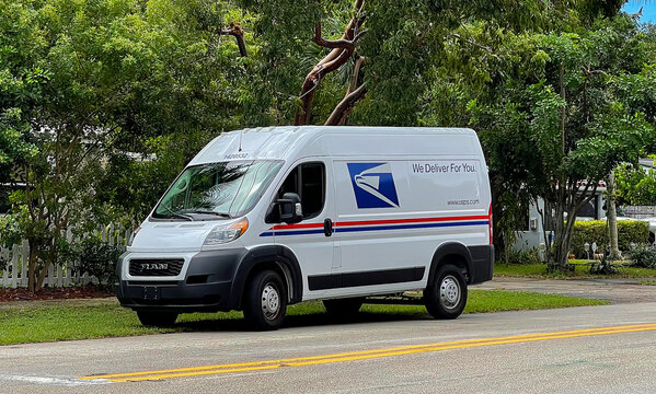 USPS Mail Delivery ProMaster truck parked in a residential neighborhood.  The ProMaster picks up and delivers packages in Fort Lauderdale, Florida, USA. 