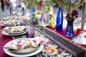 Served table for a wedding dinner. Dishes, glasses and candles for the holiday table.