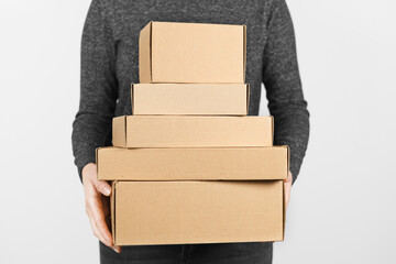 A stack of cardboard boxes in the hands of a people on a white background. Free shipping, return of...