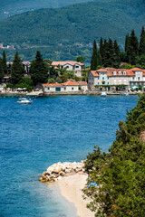 Mediterranean architecture city in Montenegro from Adriatic sea view. Scenic town with nature and mountains in sunny day