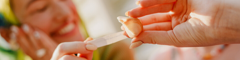 Young white women smiling while eating fortune cookie