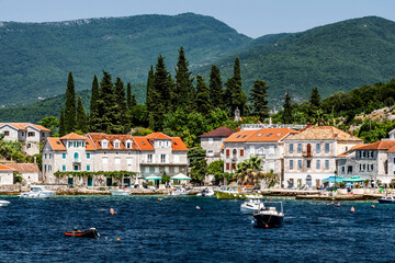 Fototapeta na wymiar Scenic Mediterranean city in Montenegro with mountains, view from Adriatic sea. Beautiful architecture with orange roofs