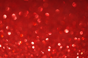 Festive abstract blurred glitter background red color. Bokeh effect. Holiday decoration concept.