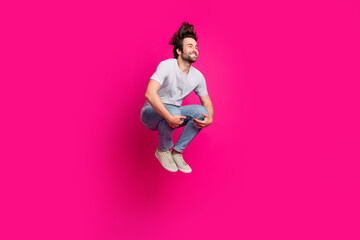 Profile photo of crazy sportive guy jump hands hold knees wear striped t-shirt jeans shoes isolated...
