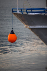 Orange mooring buoy and a ship