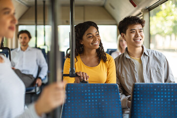 Happy asian guy and black lady taking bus together © Prostock-studio