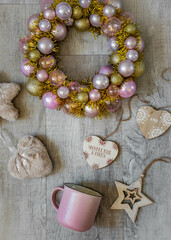 Moscow, Russia, November 2010, Christmas decor, rose gold Christmas wreath, Christmas tree decorations and a pink cup on a light wood background