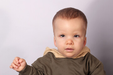 Portrait of a disabled boy with Down syndrome on a light background