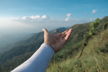 Hands outstretched to receive natural light and mountain views