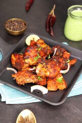 Tandoori chicken is a popular roast chicken recipe from India. Tandoor is a traditional wood oven. Chicken Tandoori Platter is served in a brass plate with salad and spices. Copy Space.