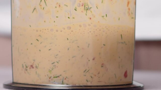 preparation of sauce from sour cream, dill, garlic and bell pepper large close-up slow motion