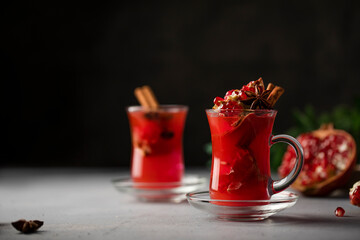 Pomegranate hot Turkish tea decorated with cinnamon sticks, seeds. Vitamin hot beverage. Copy space...