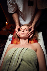 Woman on a massaging, chiropracting table, treatment of body and face skin tension.