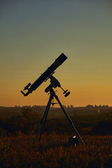 Silhouette of astronomical telescope and countryside.